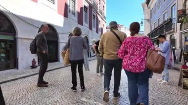 Lizbon kaldırım taşı yolu renkli evler ve yürüyen ziyaretçiler