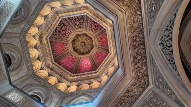 Sintra Portekiz 'deki Monserrate Sarayı' nın içindeki süslü salonda kemerler, mermer sütunlar ve altın ışık var.