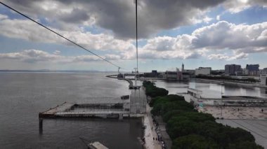 Lizbon 'da su üzerinde teleferik kablosu Portekiz bulutlu gökyüzü ve modern şehir manzarası