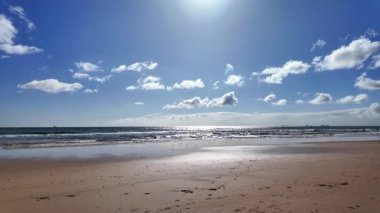 Avrupa Atlantik Denizi kıyısındaki kumda yürüyen ayakların bakış açısı