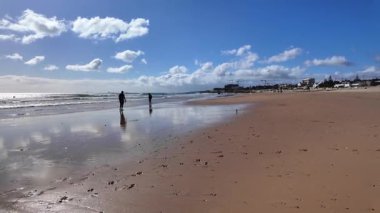 Atlantik kıyısı POV 'u berrak gökyüzü ve ayakları altındaki kumla Avrupa seyahati