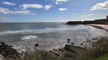 Eski Avrupa şehrinde okyanus manzaralı güneşli bir gezinti güvertesinde yürüyorum