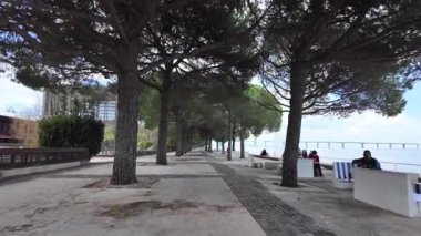 Uluslar Parkı Lizbon şehir merkezi modern kuleler ve açık mavi gökyüzü altında yürüyen insanlar