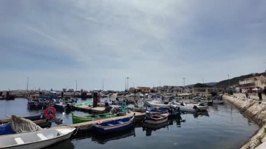 Deniz kenarındaki gezinti güvertesinde ilk kişi mavi okyanusa bakar sakin bir gün Avrupa mimarisi görünür