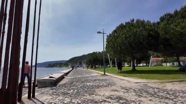 Avrupa 'da deniz manzaralı sahil yürüyüşü, büyüleyici binalar güneşli bir gün, rahatlatıcı bir tatil havası.