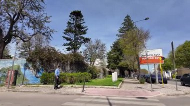 Tarihi binaların önünden geçiyor.