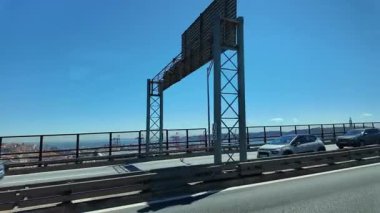 Lizbon Köprüsü 'nde trafik ve şehir manzarası. Ufuk çizgisi gezisi ve hareket halindeki arabalar.
