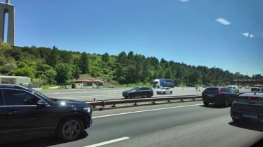 Lizbon Köprüsü 'nde hareket halindeki araba manzaralı trafik binaları gezisi ve şehir hissi