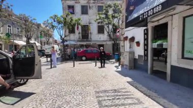 Eski Portekiz şehrinde deniz kenarında insanlarla yürümek