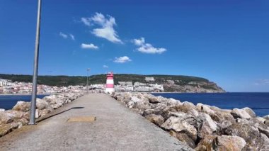 Güneşli POV Sesimbra Portekiz 'de okyanus manzaralı ve canlı binalarla yürüyor
