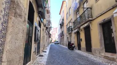 Tarihi Lizbon caddesinde geleneksel mimariyle yürüyen bir gezgin.