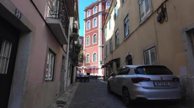 Lizbon 'da yürüyüş manzarası. Eski duvarları ve evleri olan antik bir sokak.