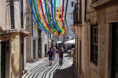 Lizbon, Portekiz 'de sokak manzarası. Renkli flamalar ve yürüyen insanlar..