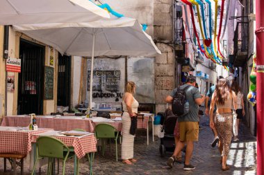 Lizbon 'da sokak manzarası, açık hava yemekleri ve renkli dekorasyonlar.