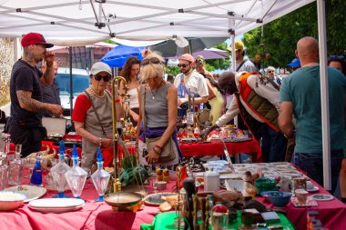 Müşteriler bit pazarında antika ve antika ürünlerine göz atıyorlar..