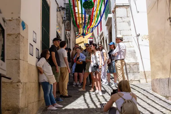 Bir grup turist Lizbon, Portekiz 'de dar bir geçidi keşfe çıktılar..