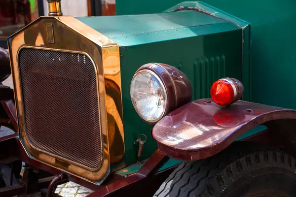 Pirinç radyatörü ve yeşil kapüşonu olan klasik bir klasik arabanın yakın çekimi.