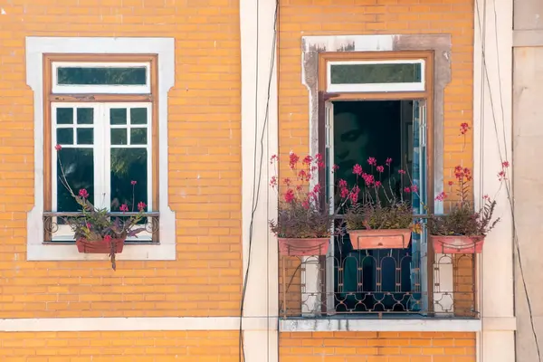 Pencereleri ve balkonları çiçeklerle süslenmiş büyüleyici bir görünüş..