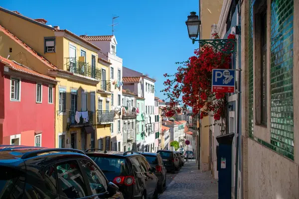 Lizbon, Portekiz 'de renkli binaların ve park edilmiş arabaların olduğu büyüleyici bir sokak manzarası.