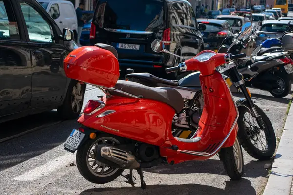 Şehrin caddesinde park etmiş kırmızı scooter.