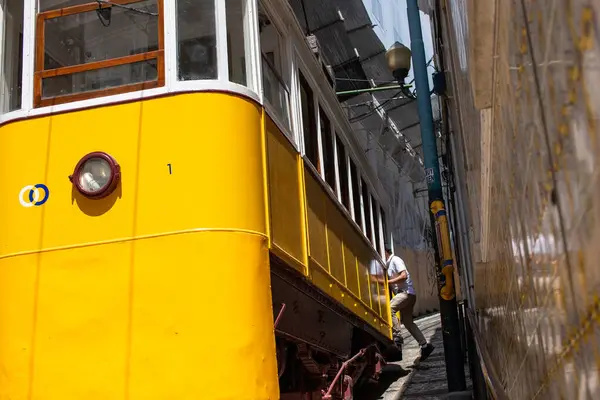 Lizbon 'da sarı tramvay dar bir sokağa giriyor.