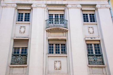 Süslü mimari detayları ve balkonu olan zarif bir bina cephesi.