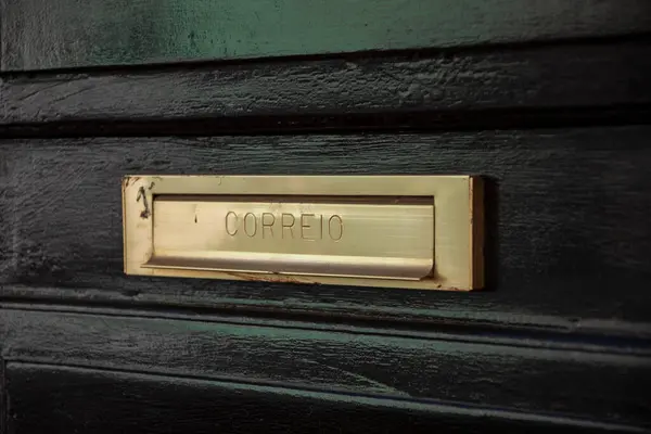 Siyah ahşap kapıdaki Correio posta deliğine yakın plan.