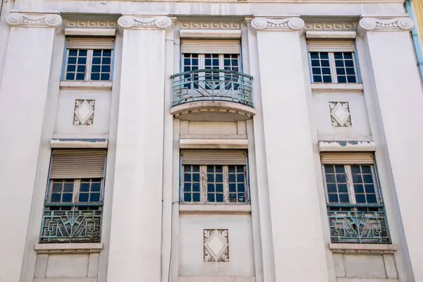 Süslü mimari detayları ve balkonu olan zarif bir bina cephesi.