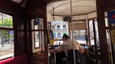 Lizbon 'un eski sokaklarına bakan tramvayın içi, geleneksel mimarisi ve kaldırımlı şeritleriyle Avrupa turizm sahnesi