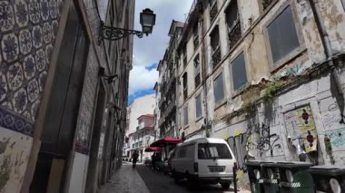 Lizbon Portekiz 'de eski binalar ve taş yollarla dolu dar bir sokakta yürüyüş.