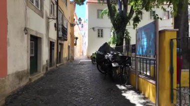 Lizbon Portekiz 'de kaldırımlı caddede eski evlerin önünden geçiyor.