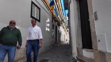 Portekiz 'in başkenti Lizbon' da eski bir sokakta yerel evlerle yürüyorum.