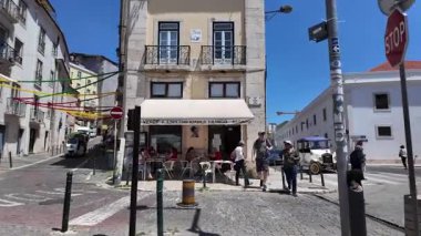 Geleneksel binalar ve fayanslı duvarlarla Lizbon 'da dar yol yürüme sahnesi