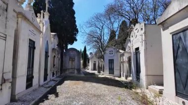 Mezarlık taş mahzenlerin ve yaşlanan mezarların yanından geçiyor.