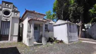 Sonbahar mezarlığında tek başına eski mezar taşlarının yanından geçiyor.