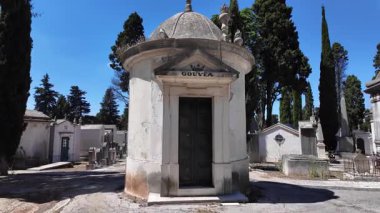 Kaliteli mezar taşları ve dökülen anıtsallar arasında yürüyen kişi