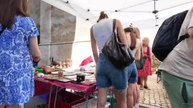 Kalabalık Avrupa bit pazarında eski antika bir dekor ve renkli tezgahlarla dolaşıyorum.