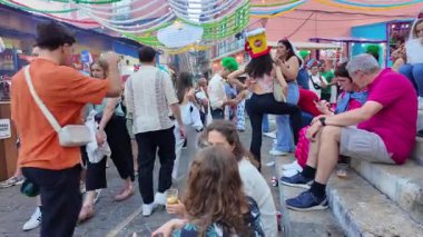 Saint Anthony festival in Lisbon with joyful crowd, food stalls, music and grilled sardines