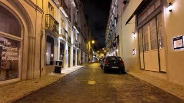 POV of night Lisbon alley glowing with vintage light