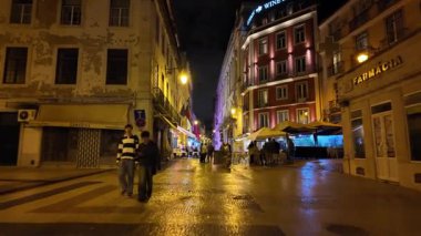 Parlak ışıkları ve eski tuğla duvarları olan sessiz Lizbon sokağı