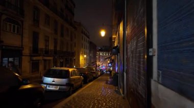 Lizbon 'da parıldayan gece lambaları olan eski bir taş sokak.