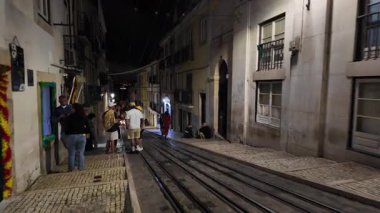 Lizbon şehir sokağı gece lambaların altında parlıyor