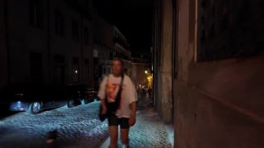 Lizbon tarihi caddesinin gece görüş açısı sarı ışıklarla dolu.