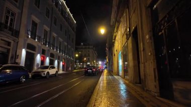 Geceleyin karamsar ışıklar ve sessiz titreşimlerle tarihi Lizbon sokakları