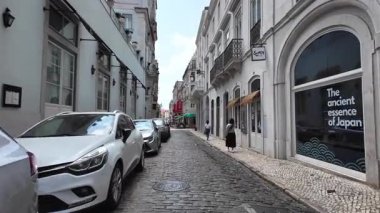 Lizbon 'da güneşli bir günde yürüyen insanların olduğu gerçek bir hayat.