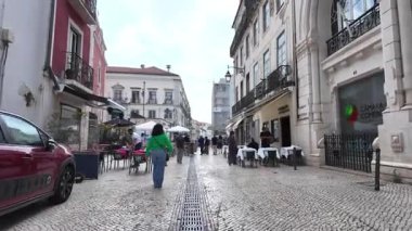 Lizbon 'un eski kasabasında insanların yürüdüğü ve yaz güneşinin parladığı şehir.