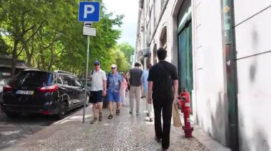 Güneşli caddelerde yürüyüş yapan otantik Lizbon sahnesi yerel kafeler ve klasik evler