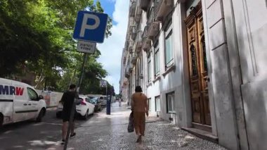 Lizbon şehri sıcak bir yaz gününde sokak sahneleri ve Portekiz cazibesiyle seyahat eder.