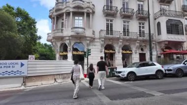 Lizbon güneşli bir yaz günü kaldırımlı caddelerde, kafelerde ve renkli evlerde dolaşır.