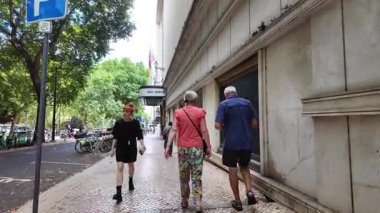 Lizbon 'un eski kasabasında insanların yürüdüğü ve yerel dükkanların açıldığı Avrupa yaz atmosferi